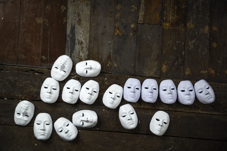 15417632 - abstract white masks on wooden background